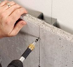 a person using a drill to fix a wall