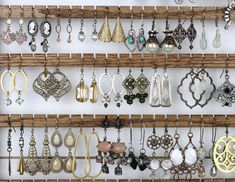 there are many different earrings hanging on the wall