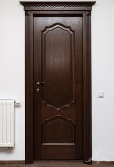 an empty room with a wooden door and radiator