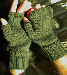 "Fingerless men's gloves are hand knit in moss green 100% superwash merino wool.   They are knit with ribbing at the wrist and knuckles for fit, and smooth stockinette stitch throughout the rest of the hand.   This style of glove includes a half thumb and one opening for all four fingers; they leave fingertips free while providing warmth to the hand.   The fabric is soft, durable and warm.  This heathered mossy green is one of my favorites.  At first glance it looks solid. but close up you can see many shades contribute to the rich color.  I tried to show this in the last photograph. One size fits most.  Laid flat, the wrist opening is approximately 6 inches in circumference, but the ribbed material allows for plenty of stretch. The gloves are approximately 9 inches end to end, and the thu Knit Handwarmers, Fingerless Gloves Men, Wool Fingerless Gloves, Gloves Men, Texting Gloves, Wool Gloves, Green Outfit, Stockinette Stitch, Mens Gloves