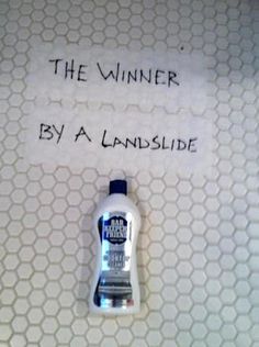 a bottle of hand sanitizer sitting on top of a white tiled floor next to a sign that says, the winner by a landfill