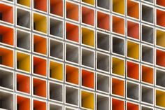 an orange and yellow tiled wall in front of a building