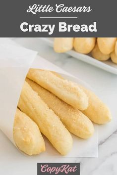 bread sticks sitting on top of a white plate next to a bowl of doughnuts