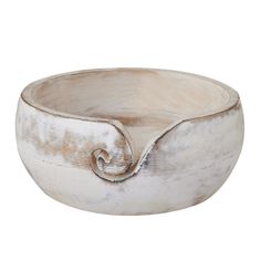 a white ceramic bowl with a curved handle