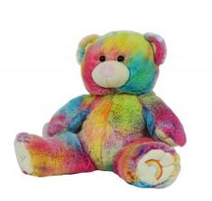 a rainbow colored teddy bear sitting up against a white background