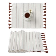 a cup of coffee sitting on top of a table next to two placemats