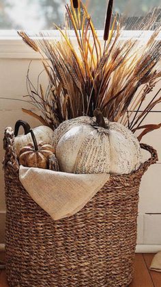 a basket filled with pumpkins and dry grass