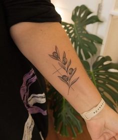 a woman with a tattoo on her arm holding the hand of another person's wrist