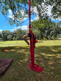 a woman is hanging upside down on a pole