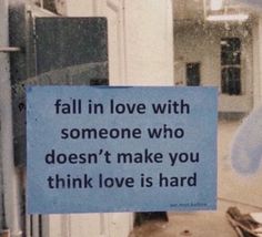 a blue sign that says fall in love with someone who doesn't make you think love is hard