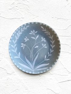 a blue and white plate sitting on top of a wall