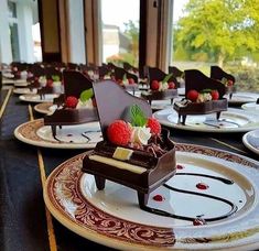 there are many plates with desserts on them that have chocolate and raspberries