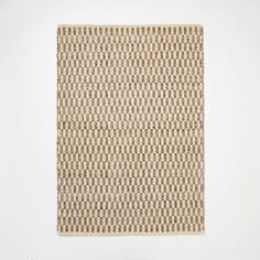 a white wall with a brown and tan rug on it