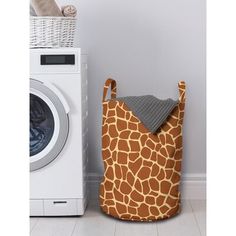 a giraffe print laundry bag next to a washing machine