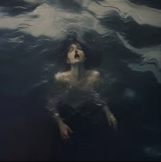 a woman floating in the water with her mouth open