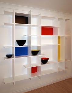 a white book shelf with bowls on it