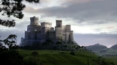 a castle sitting on top of a lush green hillside