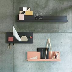 two shelves on the wall with pens and pencils