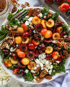 a white bowl filled with cherries, feta cheese and pecans on top of a table