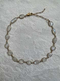 The Moonstone choker is a rare and unique. The stone is beautiful, especially in the light as it reflects light with a pearly opalescence.  The stone set in a thick 24k gold plate with a lobster claw and extension so that it can be worn as a choker or around the collar bones. The necklace itself is 12 inches with a 3 inch extension but that can be made longer upon request. Looks beautiful worn alone or layered with other pieces. The perfect gift for someone or to treat oneself. Luxury Crystal Jewelry, Raw Gemstone Jewelry Necklace, Artistic Jewelry Gold, Moonstone Beaded Necklace, Dainty Natural Stone Choker Necklace, Gold Clavicle Chain Necklace With Moonstone, Gold Spiritual Crystal Choker Necklace, Adjustable Gold Necklaces With Stones, Gold Gemstone Choker