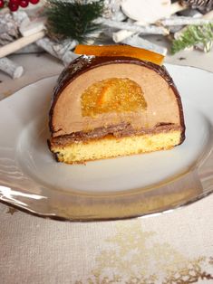 a piece of cake sitting on top of a white plate next to a christmas tree