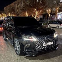 a black car is parked on the side of the road