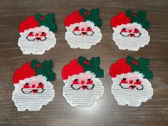 six cross stitch santa claus coasters on a table