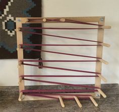 a wooden structure with several sticks attached to it and a rug hanging on the wall