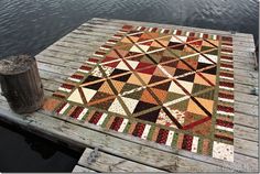 a wooden dock with a multicolored quilt on it