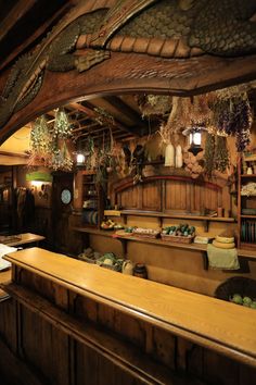 the interior of a restaurant with wooden counter tops and hanging plants on the wall above it