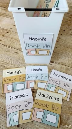 some books are sitting on the floor next to a bin with labels that say bookbins