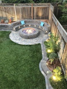 an outdoor fire pit surrounded by green grass