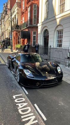 a black sports car is parked on the street