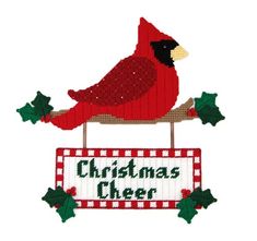 a red bird sitting on top of a christmas sign