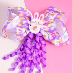 an easter decoration made out of purple paper and plastic beads on a pink background with the words happy easter written below it