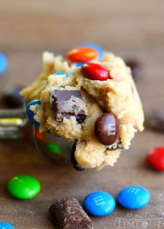 a spoon full of cookies and candy on top of a table