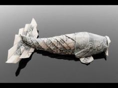 an origami fish made out of money is floating in the water with words written on it