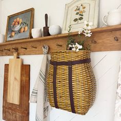 a wicker basket hanging on a wall next to a cutting board