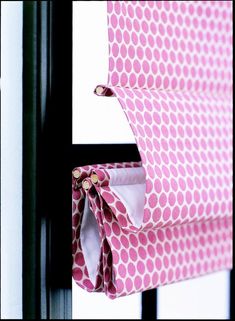 a pink and white polka dot roman blind