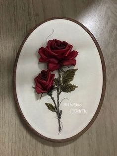 three red roses are on a white plate