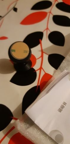 the contents of an electronic device sitting on top of a patterned tablecloth with black and orange designs