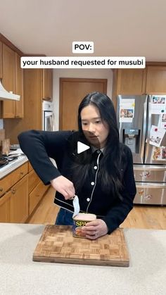 a woman standing in a kitchen preparing food on top of a wooden cutting board next to a refrigerator