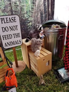 stuffed animals sit on wooden crates in front of a sign that says please don't feed the animals