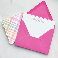 two pink envelopes with white paper on them