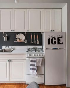 a kitchen with white cabinets and stainless steel appliances, including an icebox oven in the center