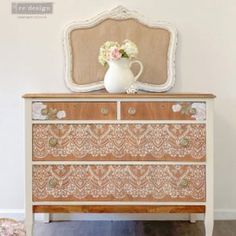 an ornate dresser with flowers in a vase on top