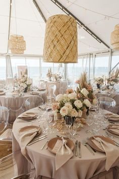 a table set up for an event with flowers and place settings