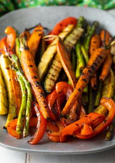 a plate with carrots, asparagus and other veggies on it