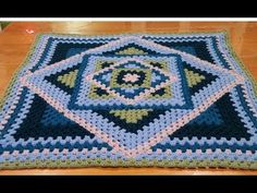 a crocheted square on top of a wooden table