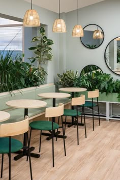 an empty restaurant with tables and green chairs